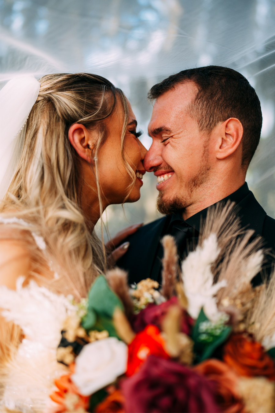 Bride and groom kissing under the veil at Ever After Farms Ranch